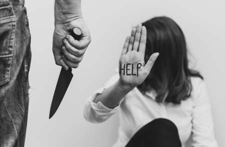 Man with knife coming to his wife. Home violence concept.の写真素材