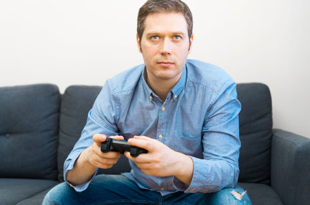 Man playing video game with gamepad in hands.