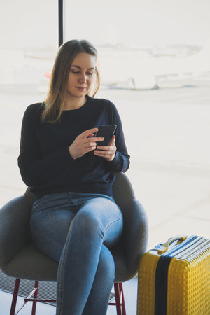 Young woman with mobile phone in the airport.