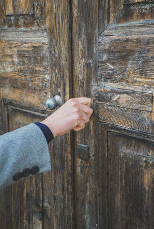 Woman opening very old wooden door.の写真素材
