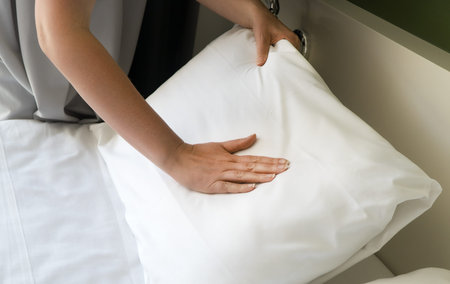 Room service. Woman making bed in hotel room.