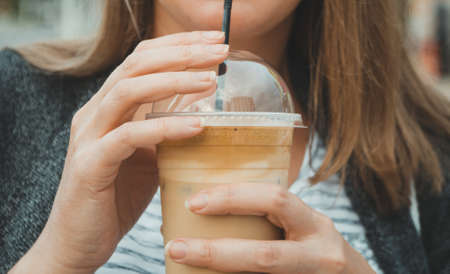 Woman's hand holding cold Frappe Coffee.の写真素材