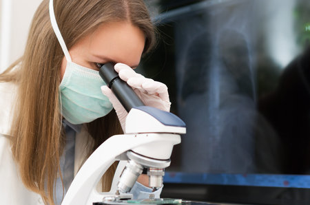Scientist in medical mask in laboratory. Pneumonia x-ray film on background.