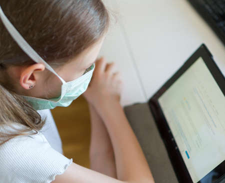 Little girl using tablet pc during quarantine.の写真素材