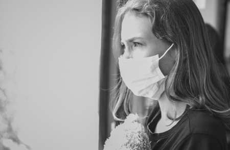 Little girl with toy on the balcony during self isolation. Stay home. Black and white.の写真素材