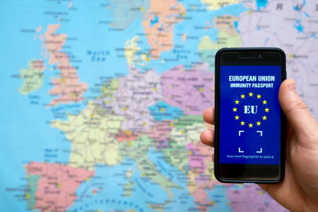 Man holding phone with European Immunity passport app. Travel during Covid-19 concept.の写真素材