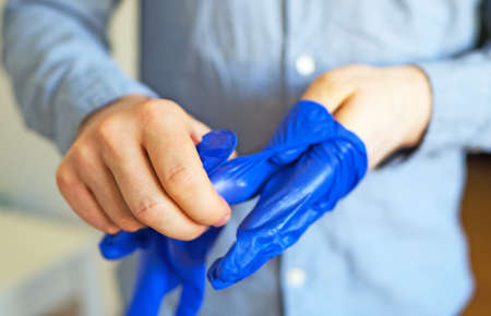 Man takes off his medical gloves. Covid-19 prevention.の写真素材