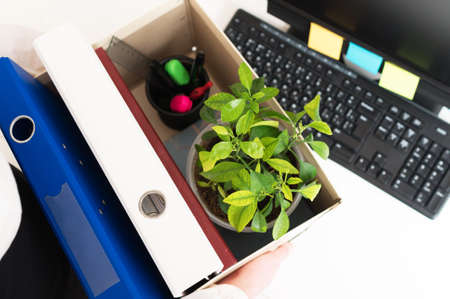 Businesswoman holding cardboard box with office stuff. Resignation concept.の写真素材