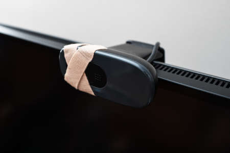 Close-up view of web camera covered with tape.の写真素材