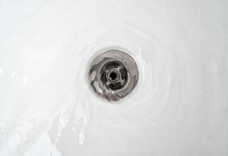 Water drains into the sink in the bathroom.の写真素材