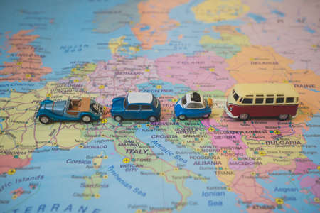 Set of small toy retro cars on the Europe map. Travel by car concept.の写真素材