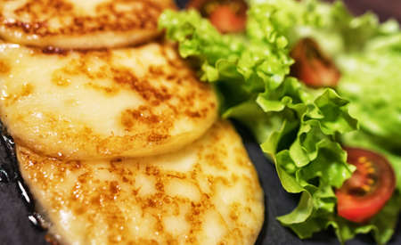 Grilled cheese with vegetables on the plate.の写真素材