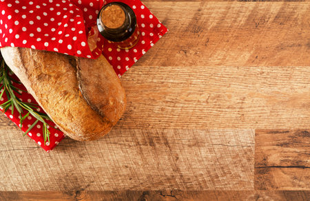 Freshly baked bread wrapped in red towel.