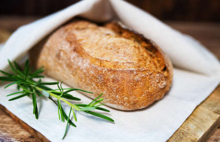 Freshly baked bread wrapped in a towel.の写真素材