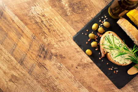 Sliced bread and rustic handmade herbs butter on the table.の写真素材