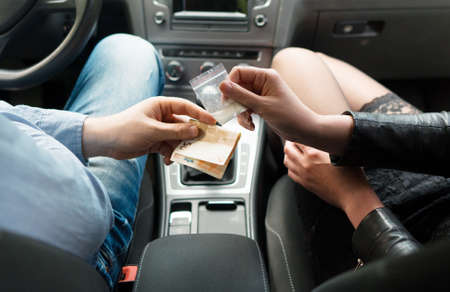 Female drug dealer sells drugs to man inside the car.の写真素材