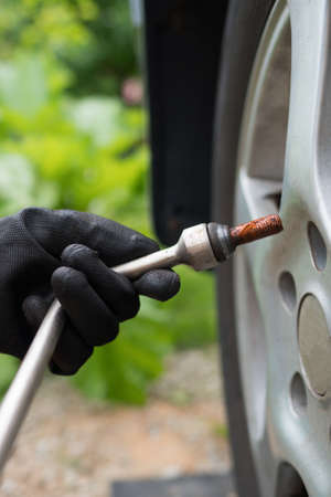 Woman changing car tire. Close-up view.の写真素材
