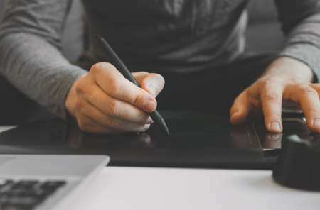 Graphic designer using electronic drawing tablet at home.の写真素材