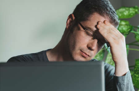 Tired exhausted man with headache in the office.の写真素材
