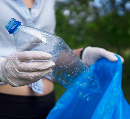 Volunteer holding plastic bottle. Environment pollution concept.