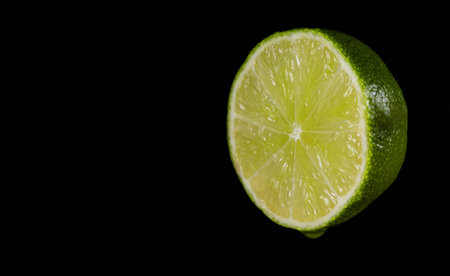 Sliced green lime on the black background.