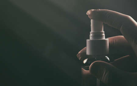 Gloved hand using disinfectant spray. Covid-19 prevention.の写真素材