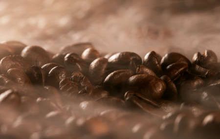 Freshly roasted coffee beans with smoke.の写真素材