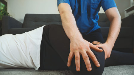 Therapist helping to do back exercise. Medical homecare.