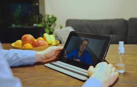 Man making video call with his doctor.の写真素材