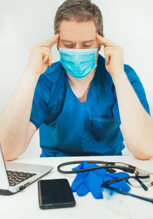 Tired medical doctor in protective mask. Burnout at work.の写真素材