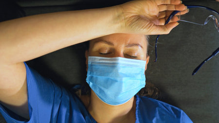 Tired medical worker after a shift. Burnout at work.の写真素材