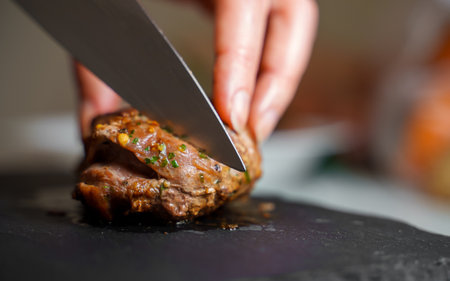 Woman cutting fried duck fillet with a knife.の写真素材