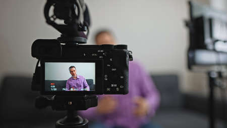 Handsome man recording his videoblog at home.の写真素材