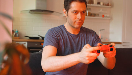 Handsome man with joystick playing racing game.