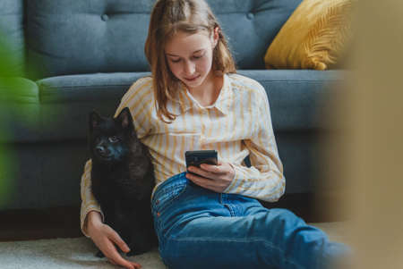 Tween girl and her dog at home.の写真素材