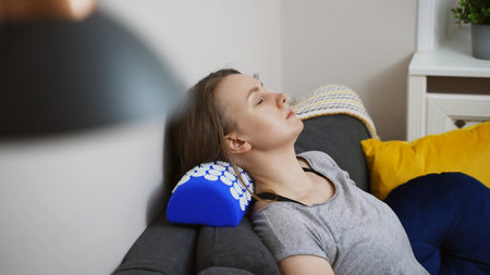 Woman is using acupuncture applicator pad for her neck.の写真素材