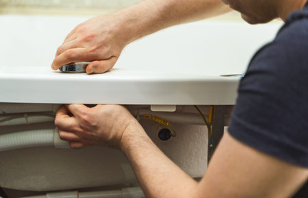 Man installing pipe system of bathtub with hydromassage.