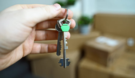 Man holding keys from new apartment. Successful moving to new flat.