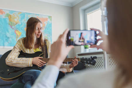 Mom records her daughter on the phone. Video blog concept.の写真素材