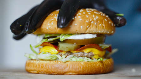 Chef in gloves presses down the finished hamburger.の写真素材