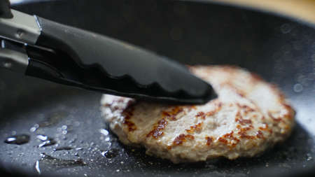 Beef cutlet for hamburger preparing on the pan.の写真素材