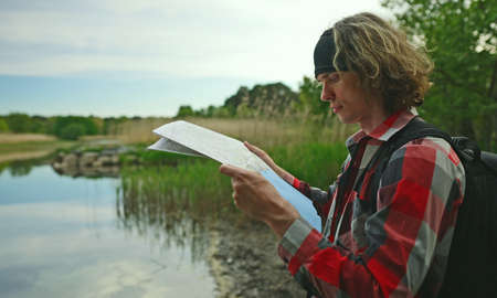 Male tourist with map by the lake.の写真素材