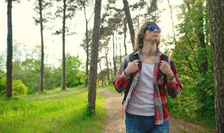 Man with backpack and sunglasses in the woods. Arc shoot.の写真素材