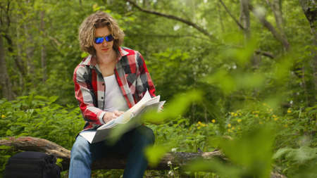 Man sits with compass and map. Orienteering.の写真素材