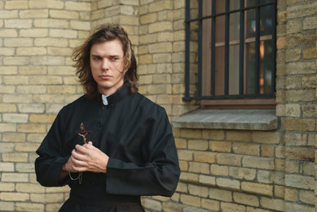 Christian priest with cross standing by the church.
