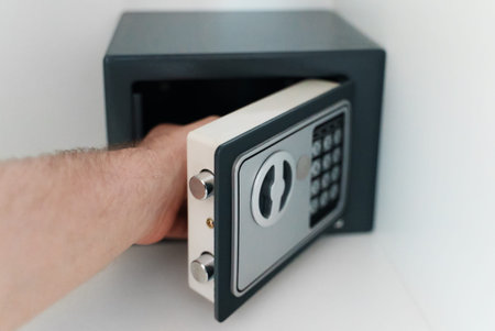 Man's hand taking something from small safe.