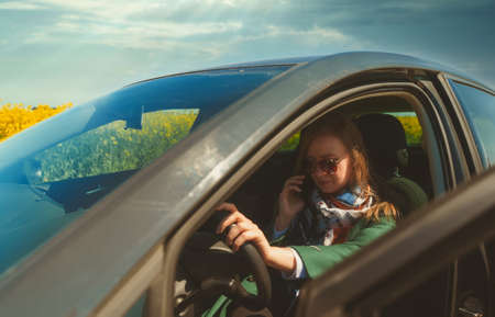 Woman calling by smartphone from the car.の写真素材