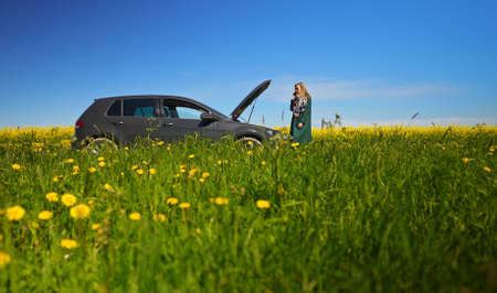 Woman near broken car calling for help.の写真素材
