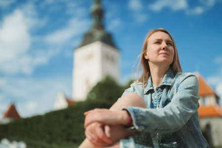 Woman resting against church in old Tallinn.の写真素材