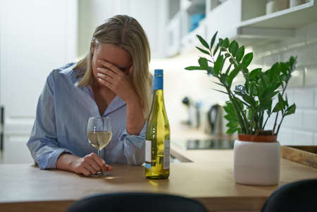 Woman suffering from depression and drinking alcohol.の写真素材